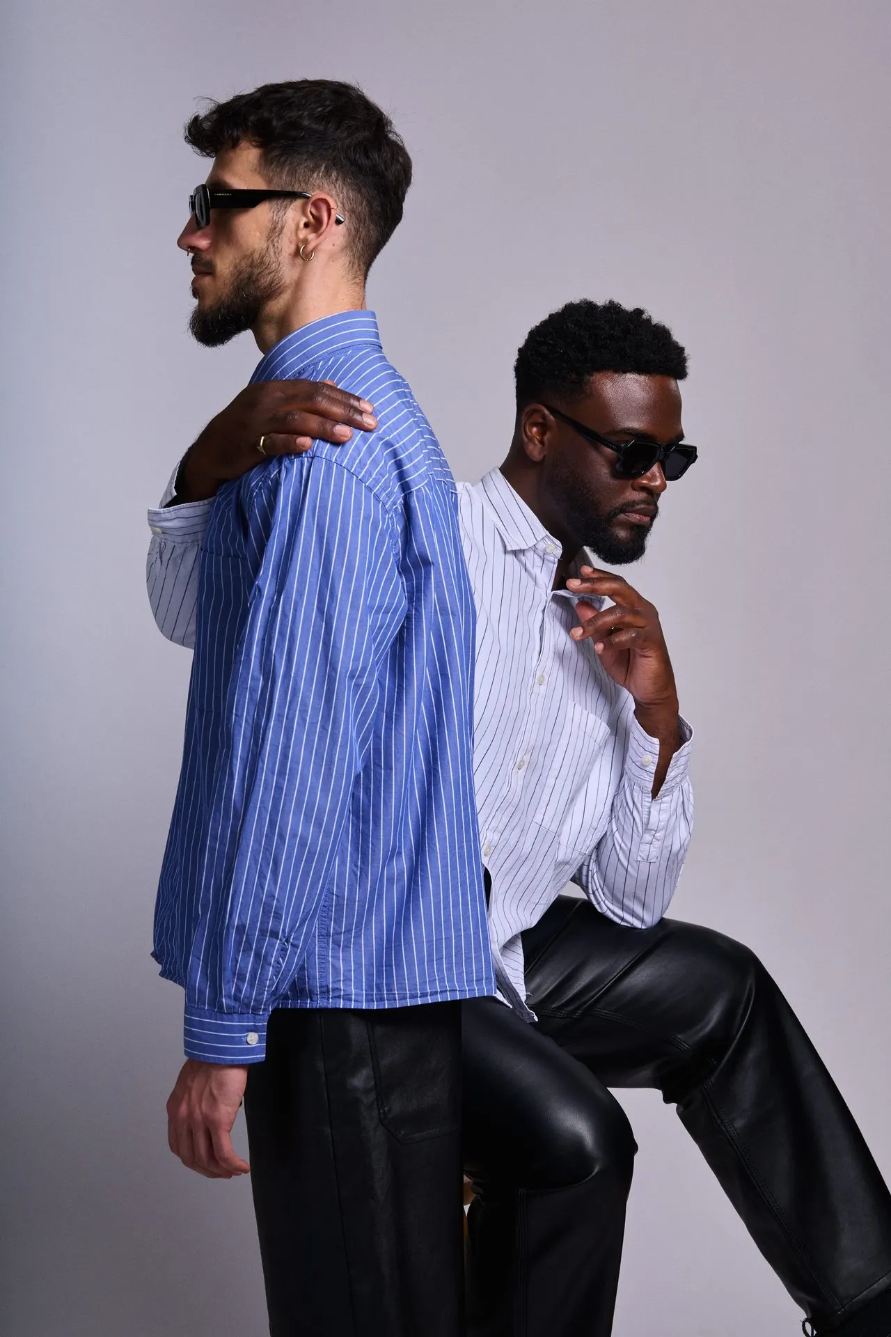 Portrait de couple en studio, deux hommes dos à dos en chemises rayées, Bruxelles
