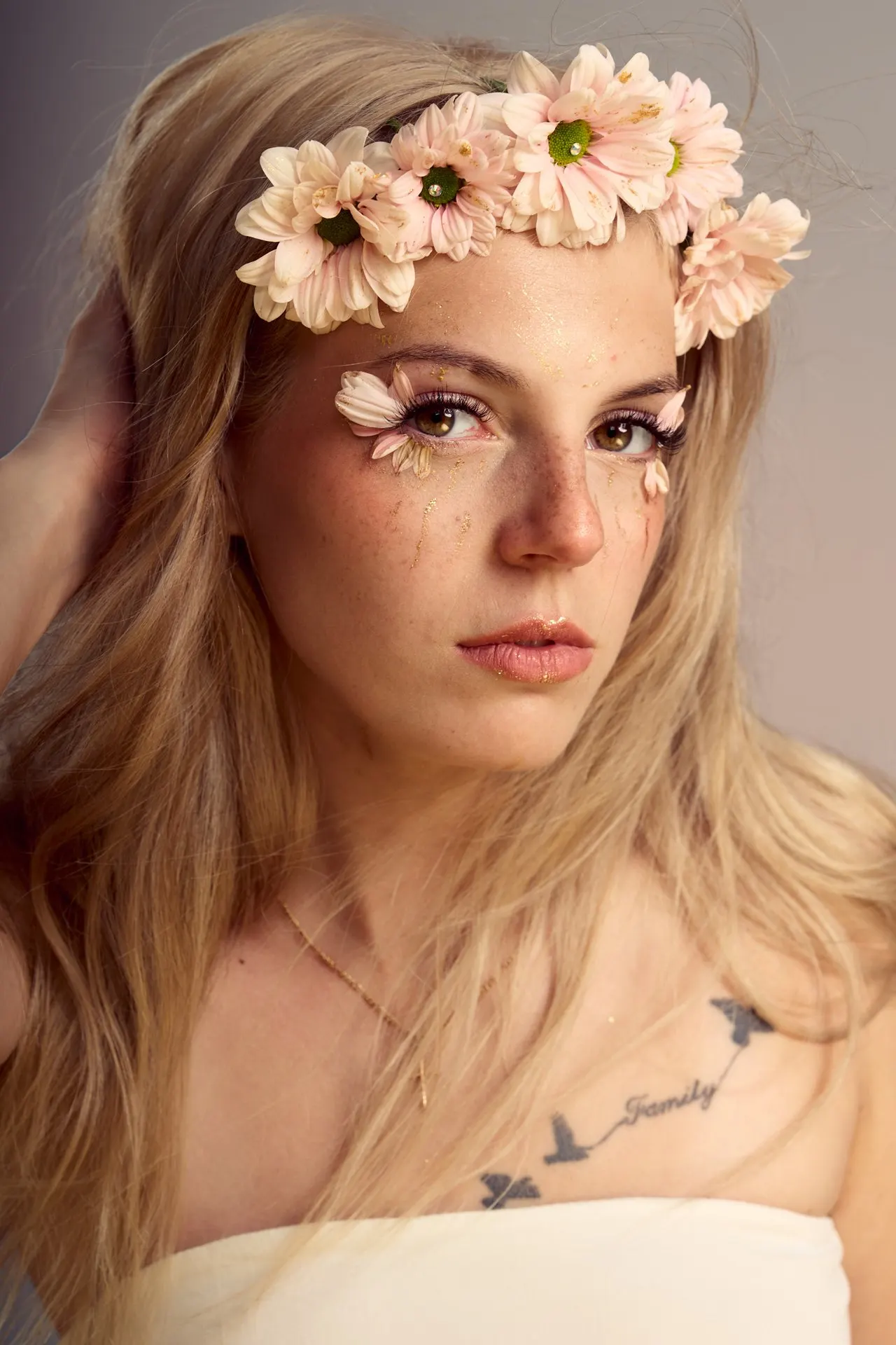 Femme blonde couronnée de fleurs, maquillage artistique et regard intense, éditorial beauté, Bruxelles