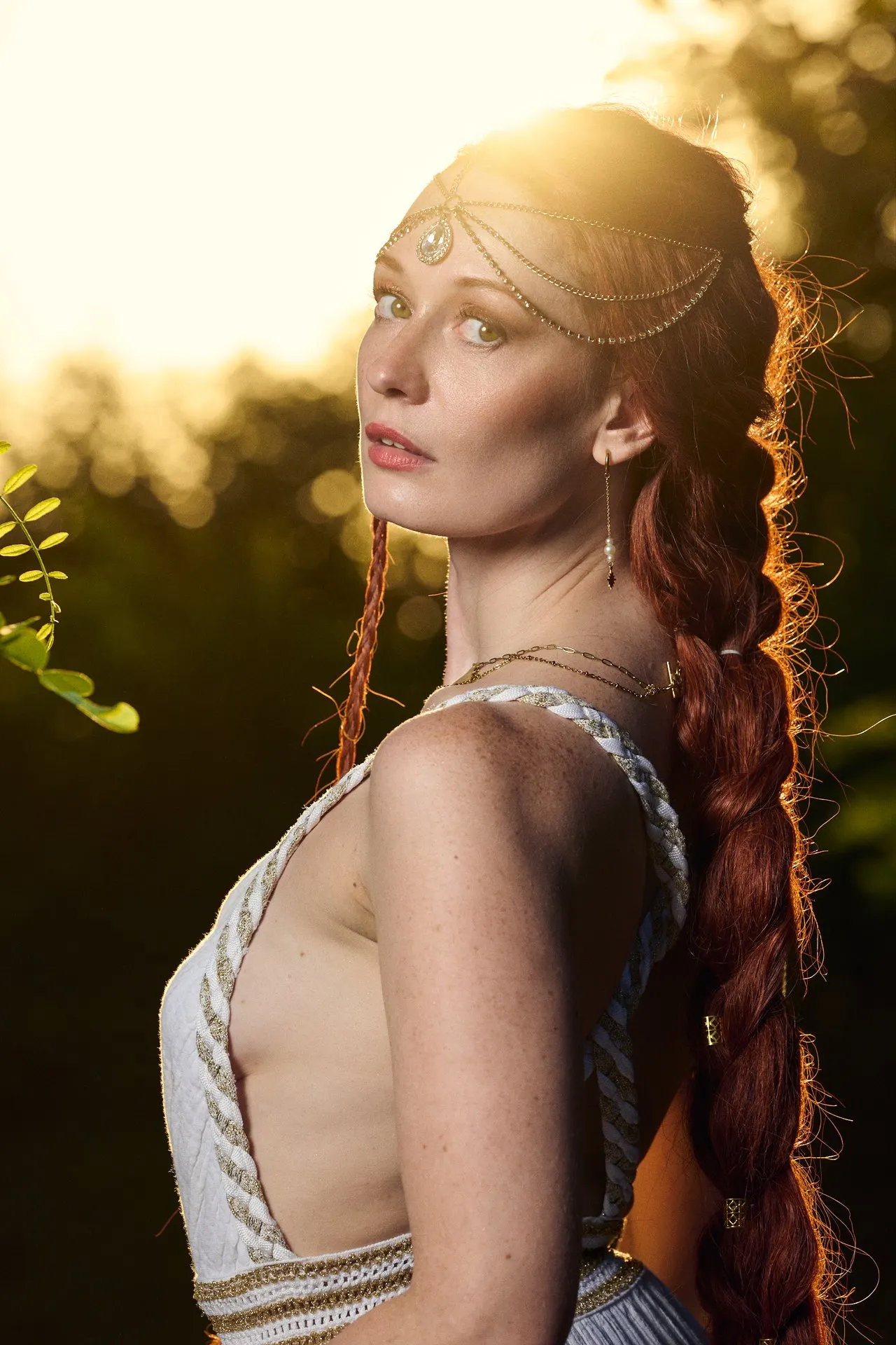 Femme rousse aux cheveux tressés en tenue argentée et diadème, lumière dorée du soir, éditorial mode, Bruxelles
