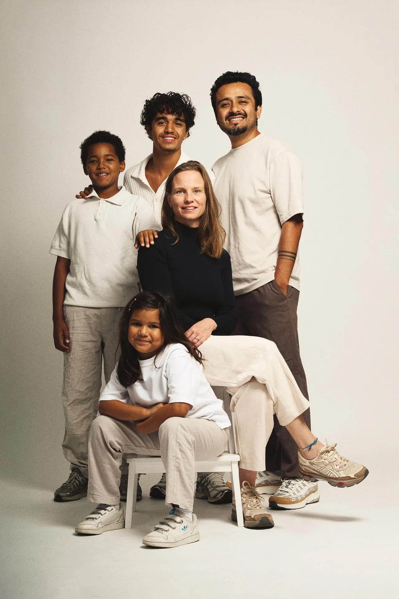 Portrait de famille de six personnes en studio, tenues claires et ambiance chaleureuse, Bruxelles
