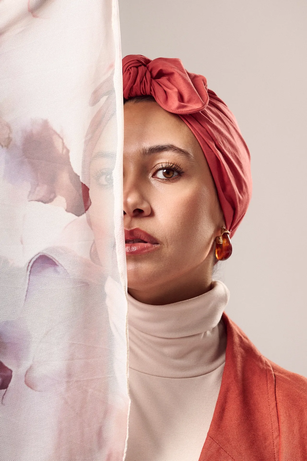 Femme en turban corail, visage à demi caché par un voile fleuri, studio, Bruxelles
