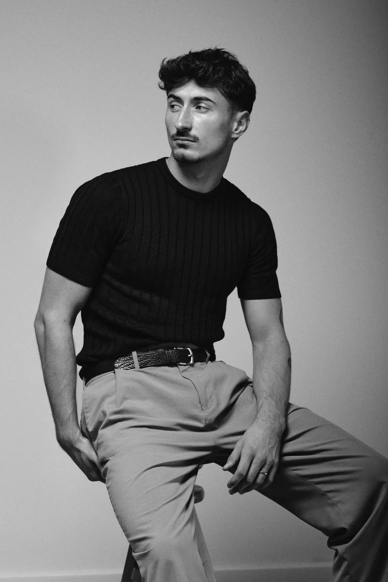Portrait noir et blanc d'un homme assis en pull côtelé, studio, Bruxelles