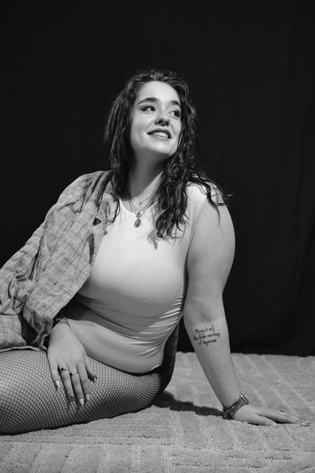 Portrait noir et blanc d'une femme souriante assise en chemise à carreaux, Bruxelles